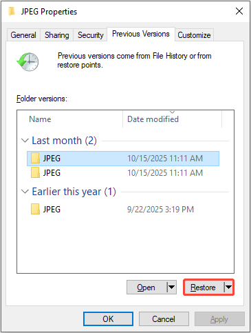 The folder properties window showing previous versions of the folder, with the Restore button highlighted.
