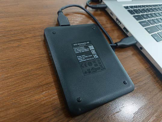 An external hard drive connected to a laptop for data backup.