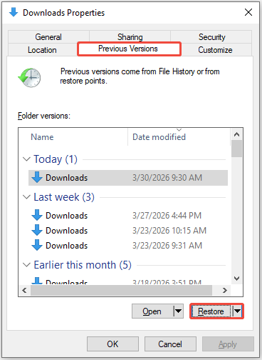 The Downloads Properties interface showing the previous versions for the Downloads folder, with Restore selected.