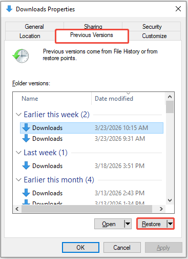 The Downloads Properties interface showing the previous versions for the Downloads folder, with Restore selected.