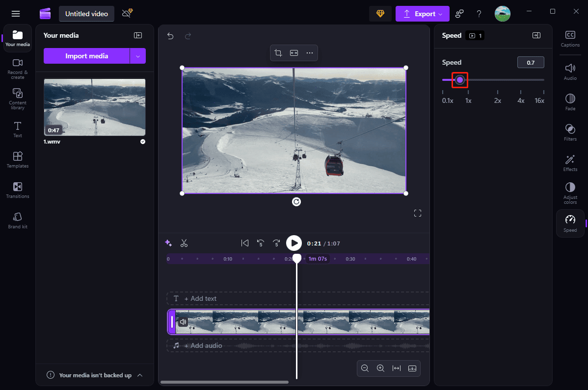 Microsoft Clipchamp interface with the Speed slider being dragged to the left to slow down the WMV file.