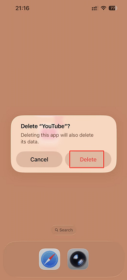 The iPhone homepage with the Delete option selected in the Delete YouTube popup.